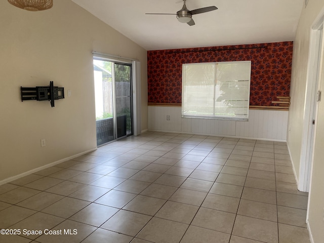 spare room with lofted ceiling, ceiling fan, and light tile patterned flooring