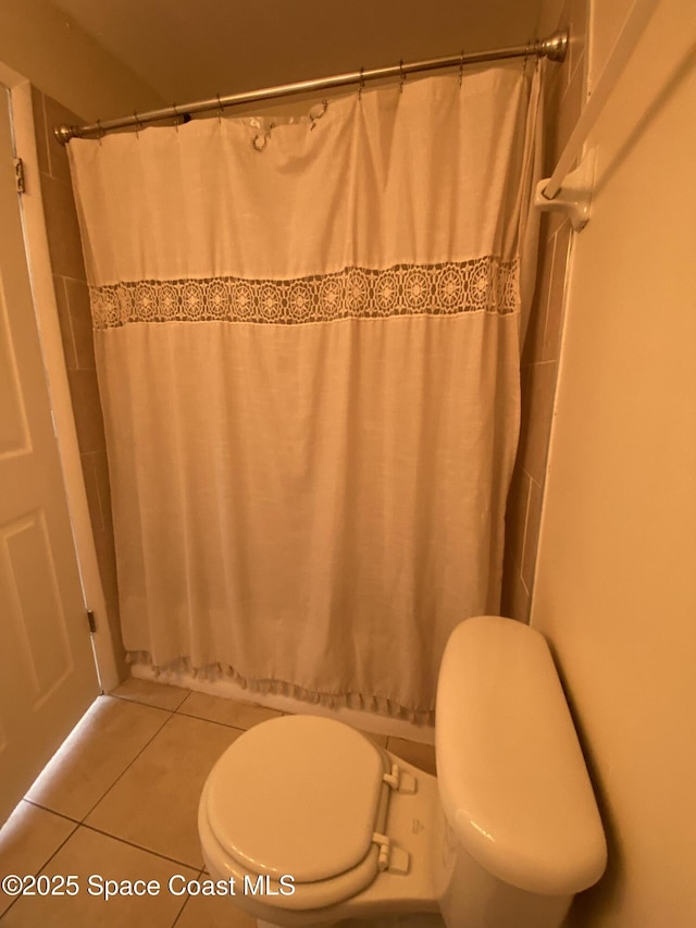 bathroom with toilet and tile patterned flooring