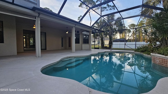 view of pool with ceiling fan, a patio area, and glass enclosure