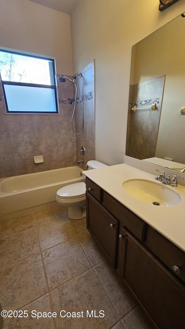 full bathroom featuring vanity, tiled shower / bath combo, and toilet