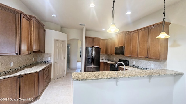 kitchen featuring black range with electric stovetop, a breakfast bar, hanging light fixtures, kitchen peninsula, and stainless steel refrigerator with ice dispenser