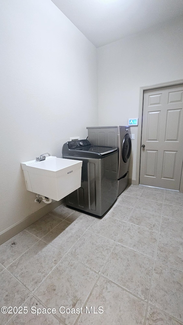 laundry area featuring sink, independent washer and dryer, and light tile patterned flooring