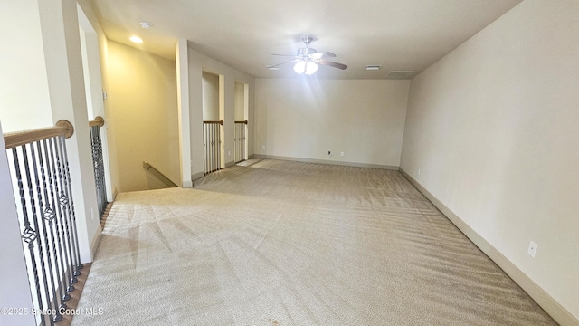 empty room featuring ceiling fan and light colored carpet