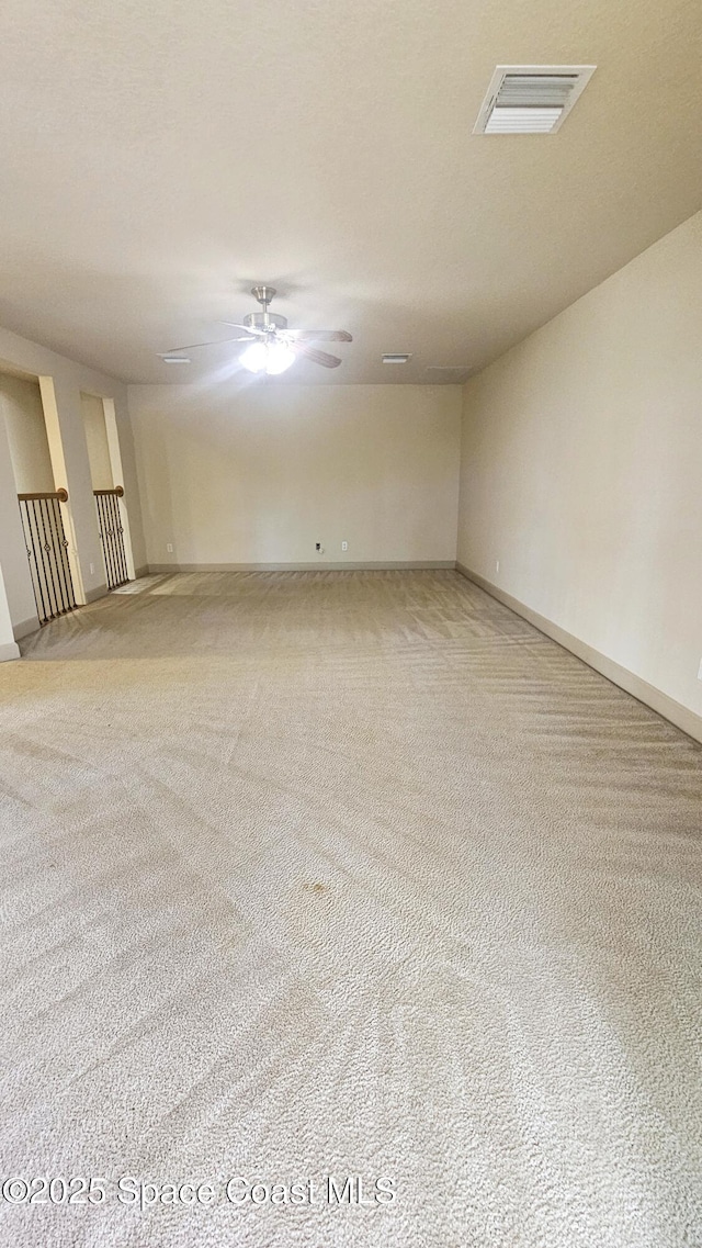 carpeted spare room featuring ceiling fan