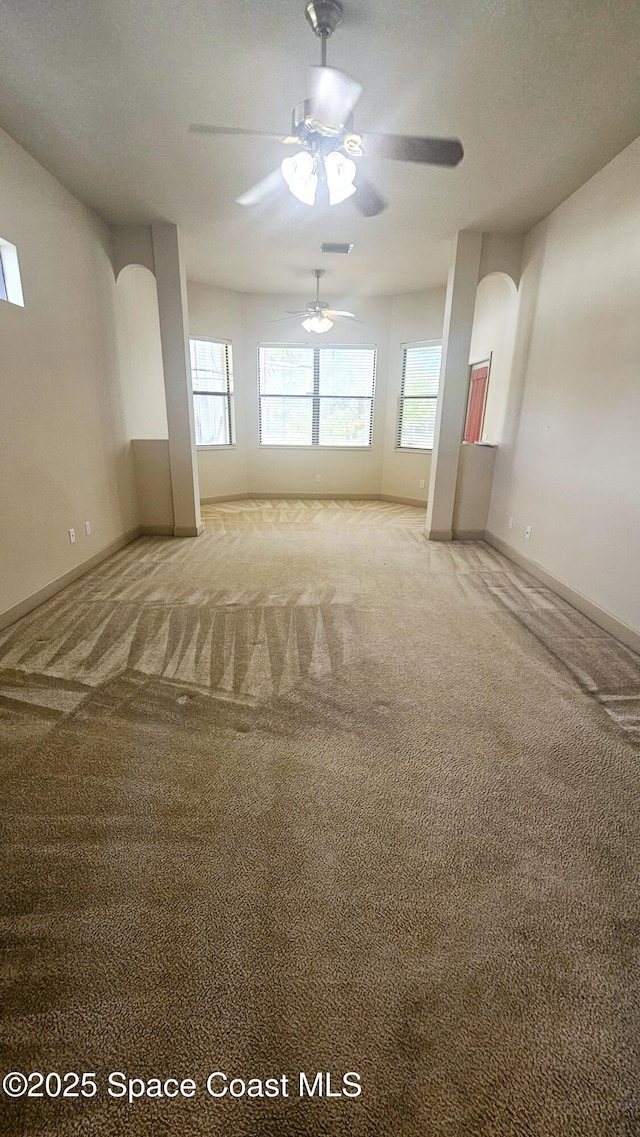 carpeted spare room featuring a textured ceiling, plenty of natural light, and ceiling fan