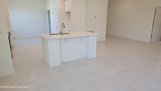 8060 Lana Ct, Micco, FL 32976 - kitchen featuring white cabinetry, sink, a kitchen island with sink, and a breakfast bar