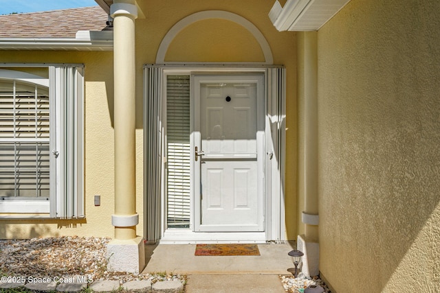 926 Pine Creek Cir NE, Palm Bay, FL 32905 - doorway to property with stucco siding and roof with shingles