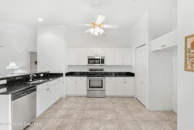 926 Pine Creek Cir NE, Palm Bay, FL 32905 - kitchen with appliances with stainless steel finishes, a high ceiling, a ceiling fan, white cabinets, and a peninsula