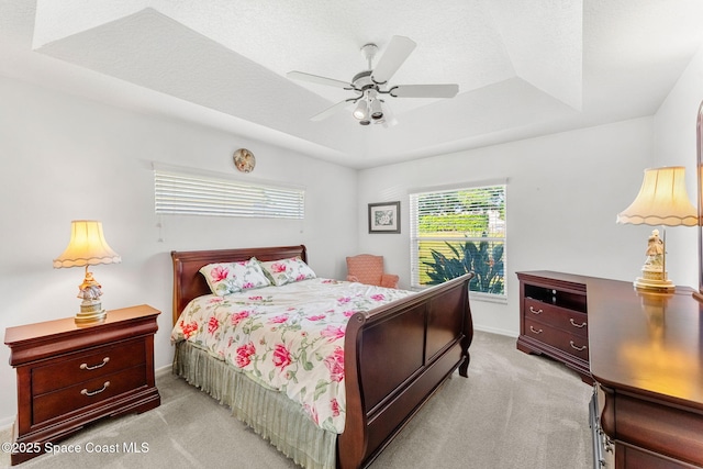 926 Pine Creek Cir NE, Palm Bay, FL 32905 - bedroom with light colored carpet, a raised ceiling, and a ceiling fan