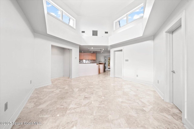 unfurnished living room with a high ceiling