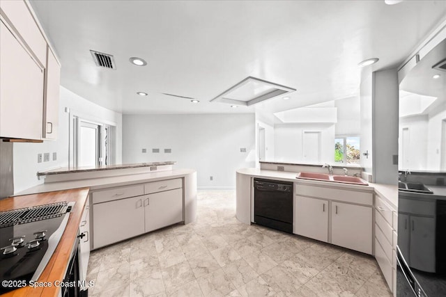 kitchen featuring sink, kitchen peninsula, white cabinets, and black appliances