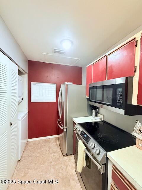 kitchen featuring stainless steel appliances and stacked washer / drying machine