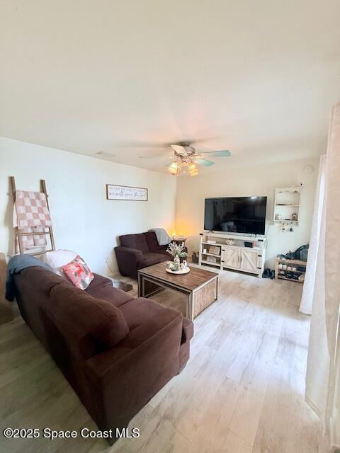 living room featuring ceiling fan and light wood-type flooring