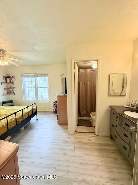 bathroom featuring hardwood / wood-style flooring, vanity, ceiling fan, toilet, and a textured ceiling