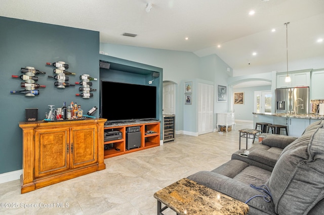 living room featuring wine cooler and vaulted ceiling