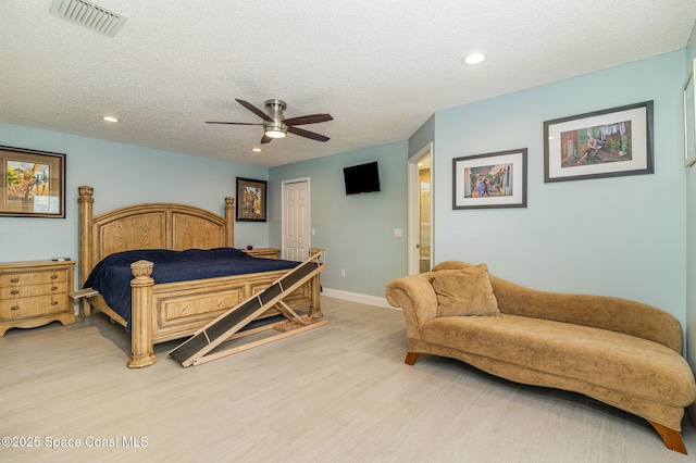 bedroom with ceiling fan, a textured ceiling, and light wood-type flooring