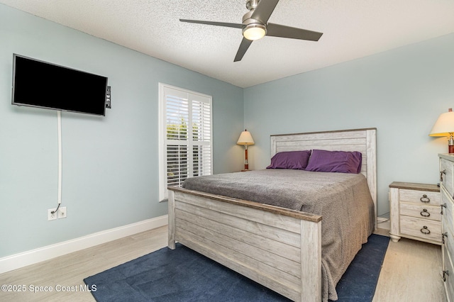 bedroom with wood-type flooring, ceiling fan, and a textured ceiling