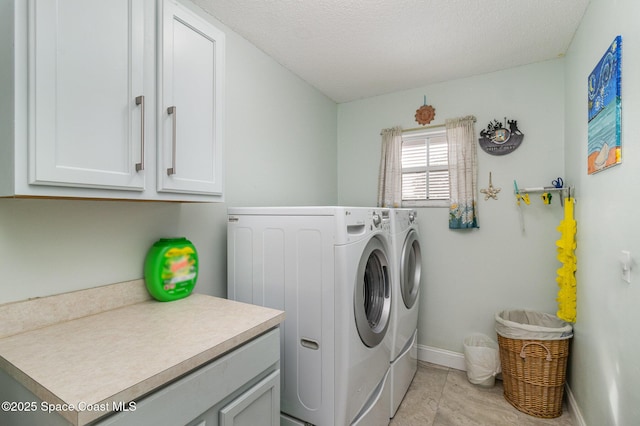 laundry area featuring cabinets, a textured ceiling, and washer and clothes dryer