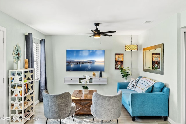 living room with light hardwood / wood-style flooring and ceiling fan