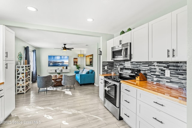 kitchen featuring wooden counters, ceiling fan, backsplash, stainless steel appliances, and white cabinets