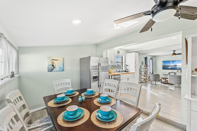 dining area with ceiling fan, sink, and light wood-type flooring