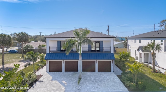 view of front of property with a garage, a front lawn, and a balcony