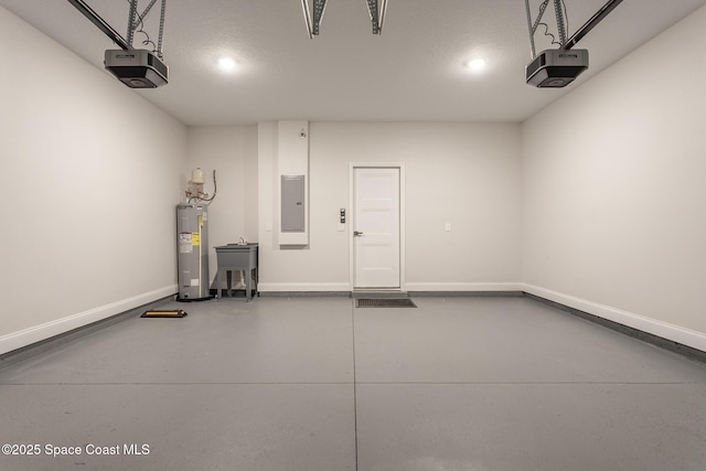 garage featuring a garage door opener, sink, electric panel, and electric water heater