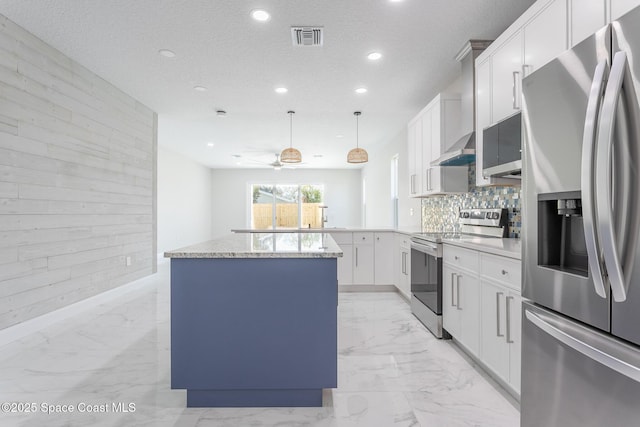 kitchen with a kitchen island, white cabinets, hanging light fixtures, kitchen peninsula, and stainless steel appliances