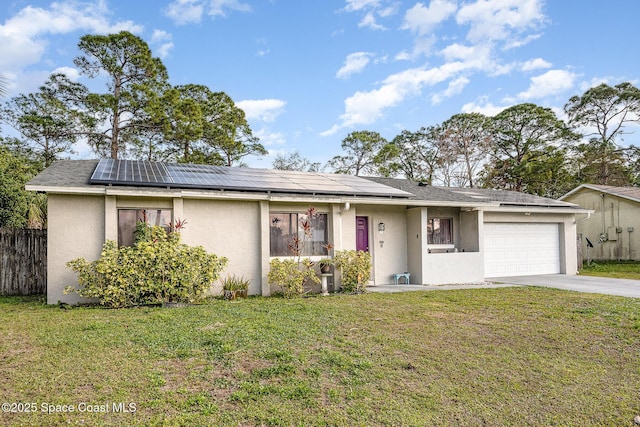 ranch-style home featuring a garage, a front yard, and solar panels