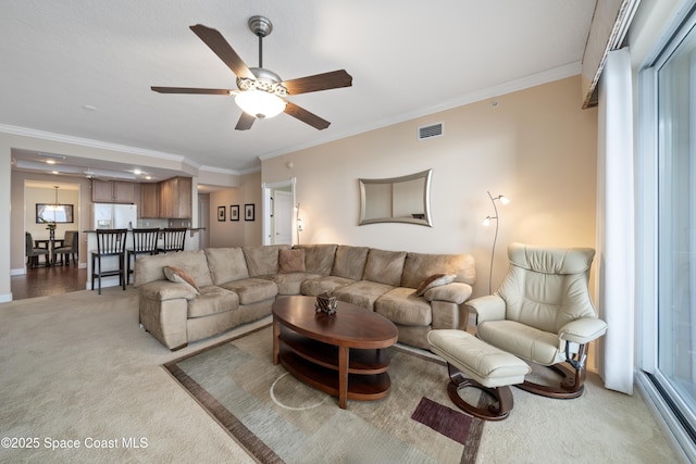 carpeted living room with ceiling fan and ornamental molding