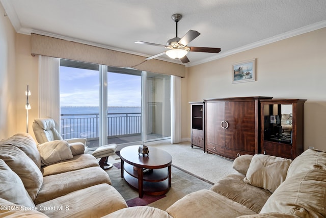 carpeted living room with crown molding, a textured ceiling, ceiling fan, and a water view