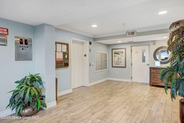 interior space featuring light hardwood / wood-style floors, a mail area, and elevator