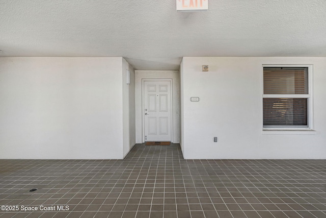 unfurnished room with a textured ceiling