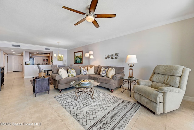 living room featuring ornamental molding, ceiling fan with notable chandelier, light tile patterned floors, and a textured ceiling