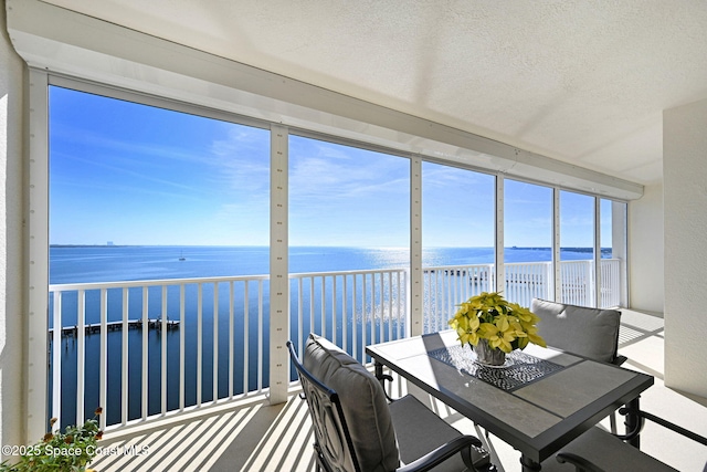 unfurnished sunroom with a water view