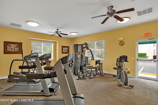 exercise room with plenty of natural light, light colored carpet, and ceiling fan