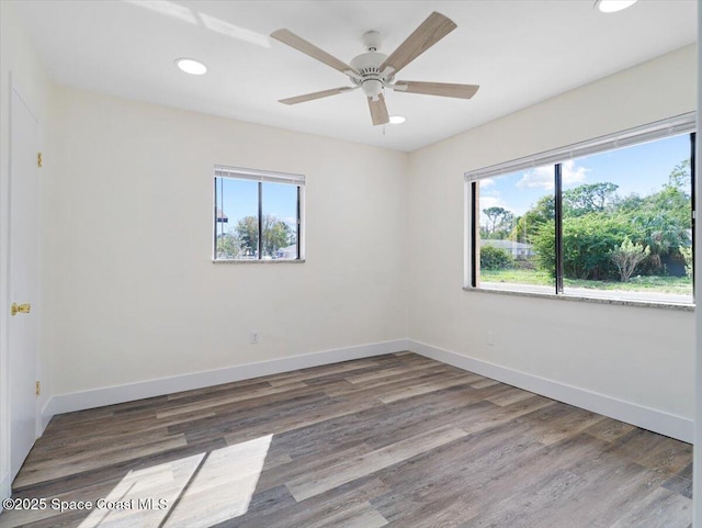 empty room with ceiling fan and dark hardwood / wood-style floors