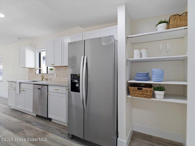 kitchen featuring sink, dark wood-type flooring, appliances with stainless steel finishes, white cabinets, and decorative backsplash