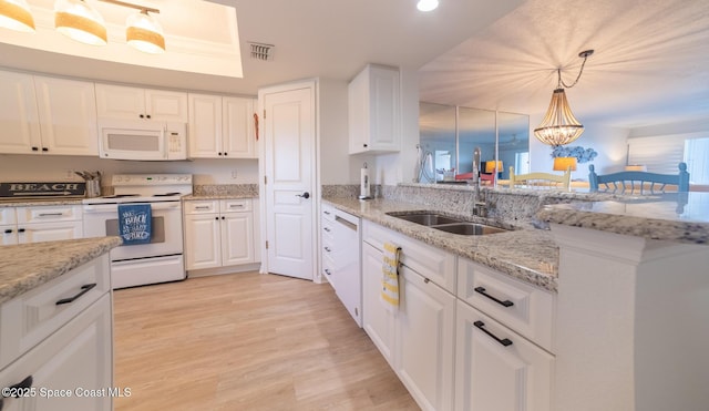 kitchen with sink, white cabinetry, hanging light fixtures, white appliances, and light stone countertops