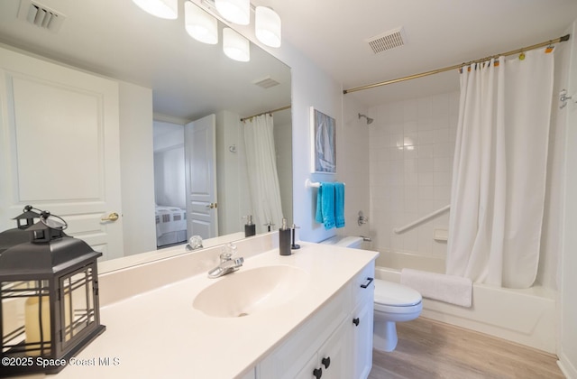 full bathroom with vanity, hardwood / wood-style floors, toilet, and shower / bath combo with shower curtain