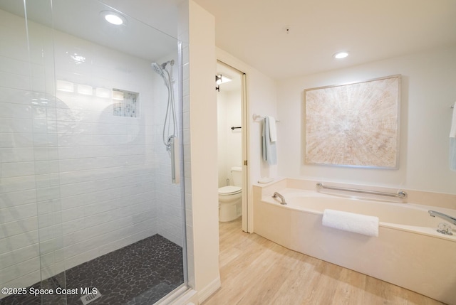 bathroom featuring hardwood / wood-style flooring, toilet, and separate shower and tub