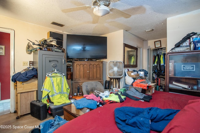 interior space featuring ceiling fan, hardwood / wood-style floors, a closet, and a textured ceiling