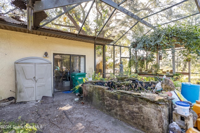 view of patio featuring glass enclosure