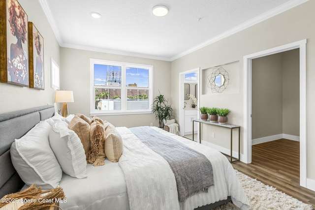 bedroom featuring hardwood / wood-style floors, ensuite bath, and ornamental molding