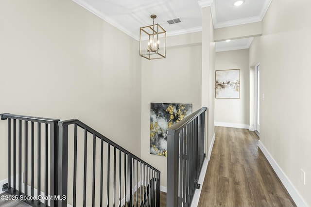 staircase featuring wood-type flooring and ornamental molding