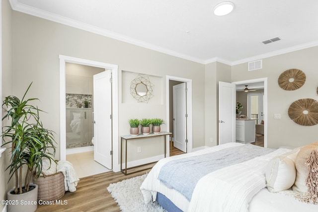 bedroom featuring ensuite bathroom, ornamental molding, and hardwood / wood-style floors