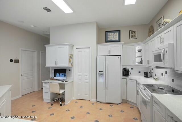 kitchen with white cabinetry, white appliances, and tasteful backsplash