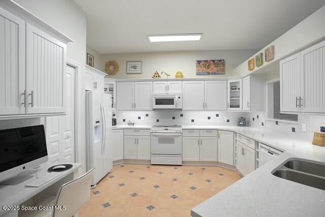 kitchen featuring white cabinetry, sink, and white appliances