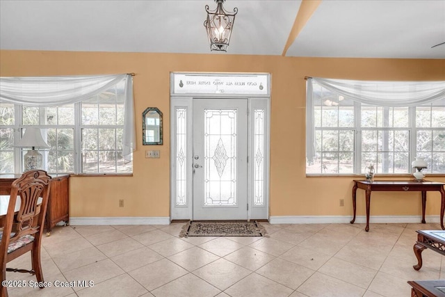 tiled entryway featuring an inviting chandelier and a wealth of natural light