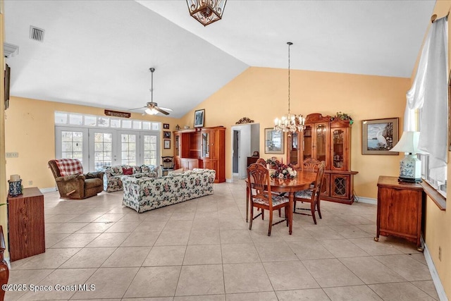 living room with light tile patterned floors, ceiling fan with notable chandelier, and vaulted ceiling